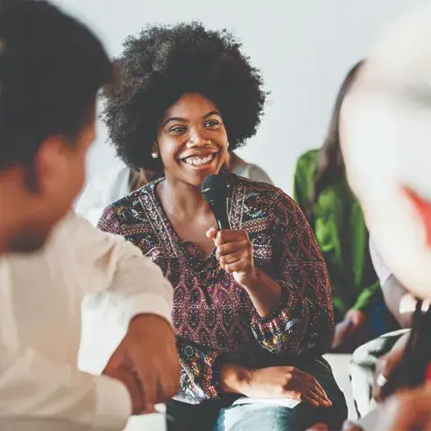 Slieshow-Images_0002_cheerful-woman-speaking-on-a-microphone-in-a-works-2023-11-27-04-56-32-utc